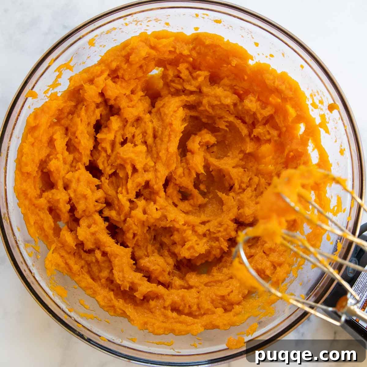 Creamy mashed sweet potatoes in a bowl, ready for mixing.