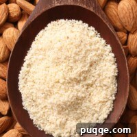 A wooden spoon filled with almond flour.