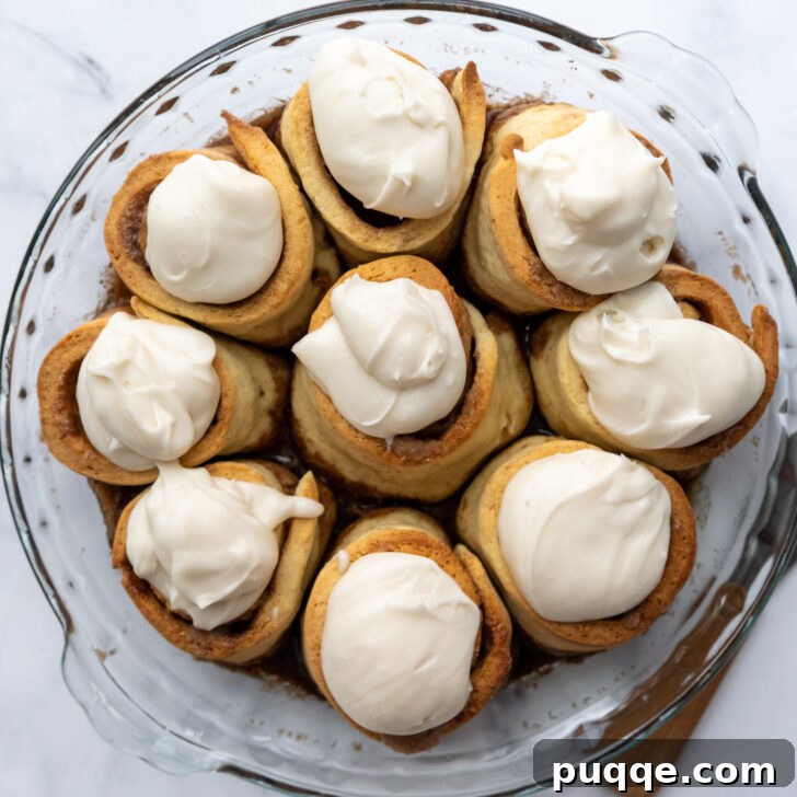 Cloud-Like Gluten-Free Cinnamon Rolls 9 Freshly baked gluten-free cinnamon rolls with dollops of white frosting melting onto their warm, golden-brown tops.