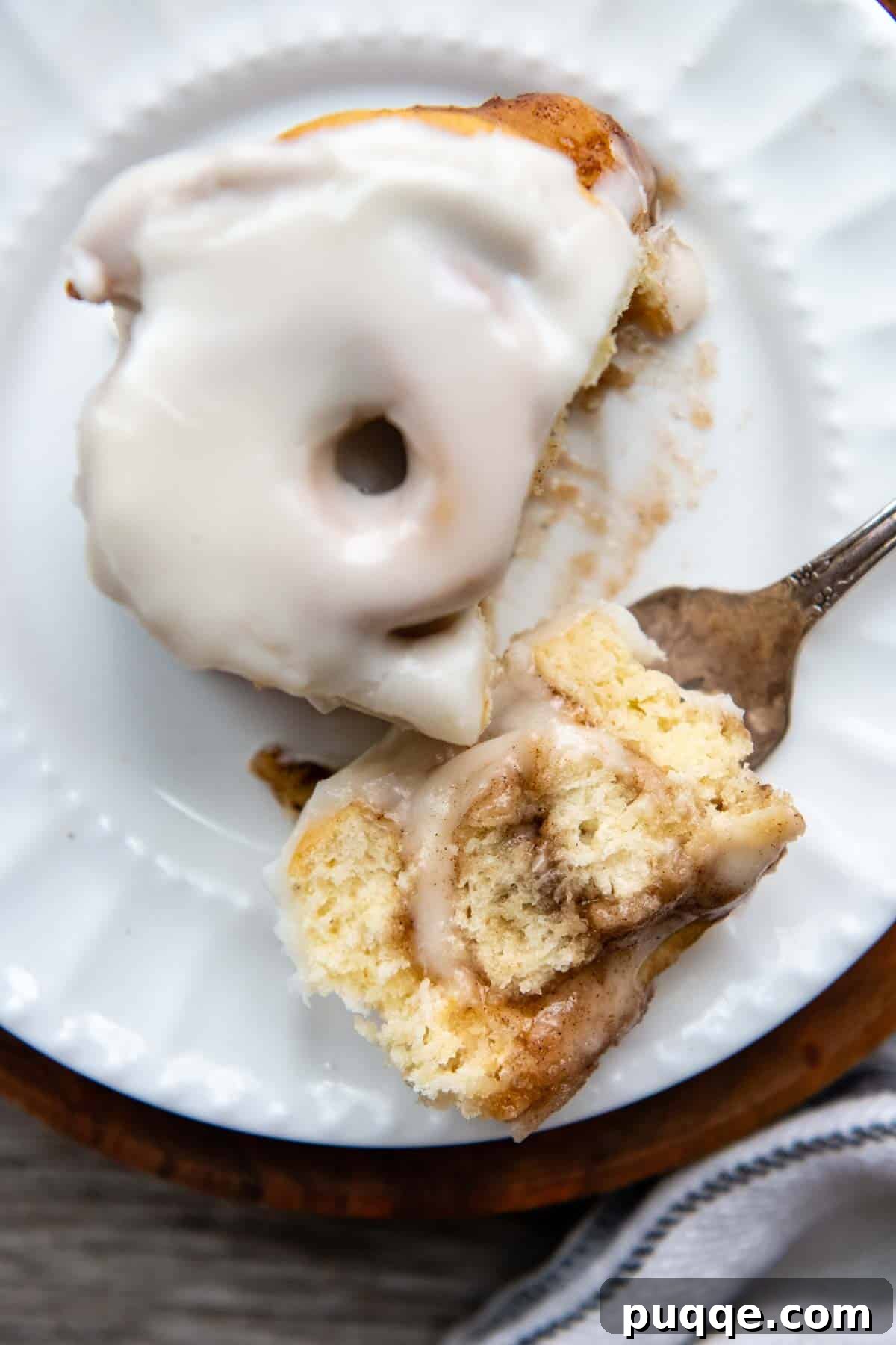 Cloud-Like Gluten-Free Cinnamon Rolls 10 a bite of cinnamon roll on a fork facing up, showing the soft interior and gooey filling.