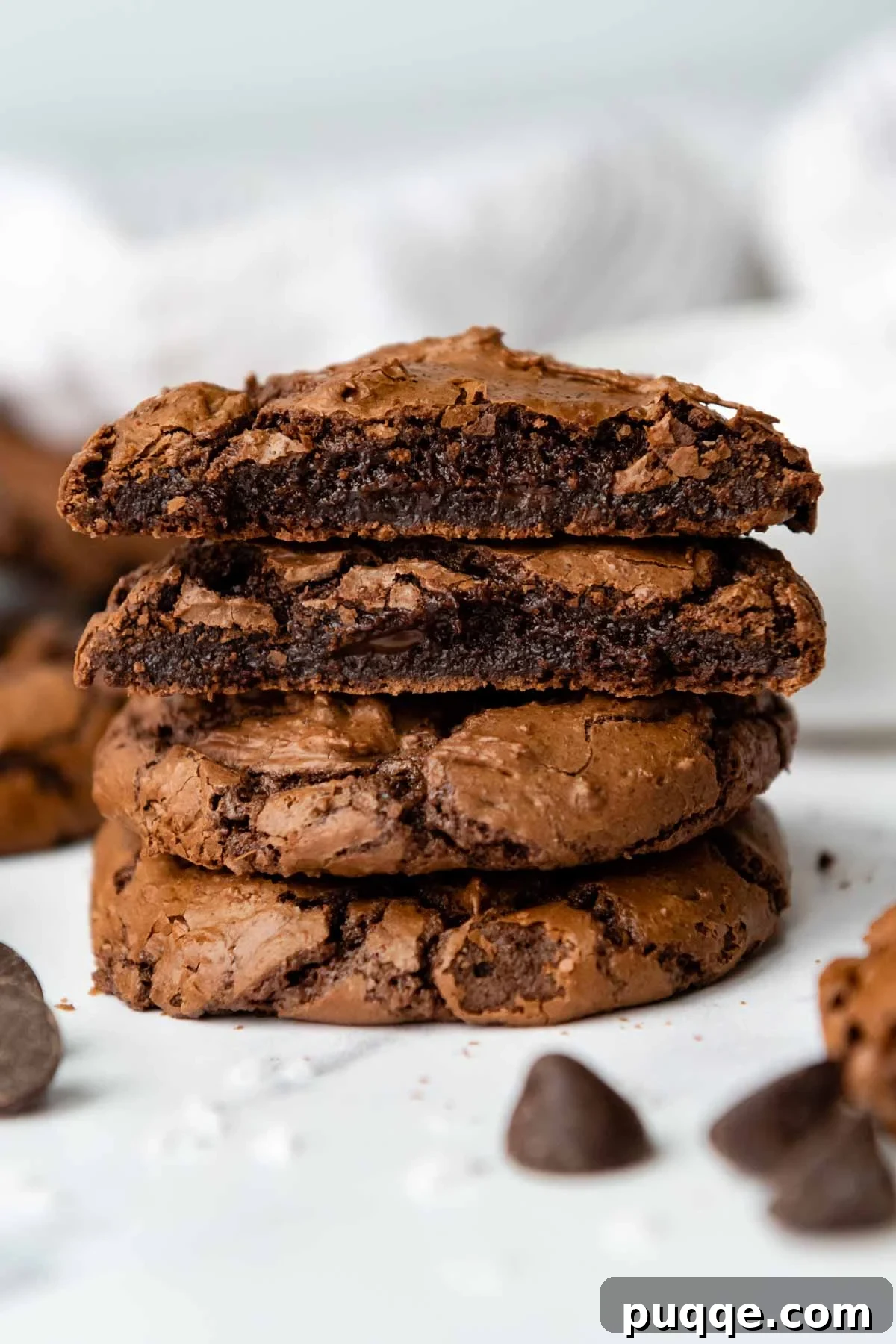 Effortless Gooey Gluten Free Brownie Cookies 2 A delectable stack of gluten-free chocolate brownie cookies, with the top two gently broken open to reveal their moist, fudgy interiors.