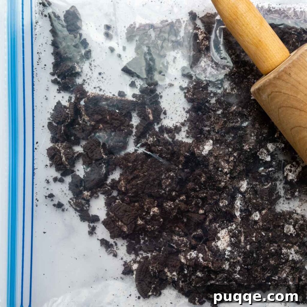 Velvet Smooth Gluten-Free Oreo Cheesecake Bliss 6 A rolling pin crushing gluten-free Oreo cookies in a resealable bag for the cheesecake filling.