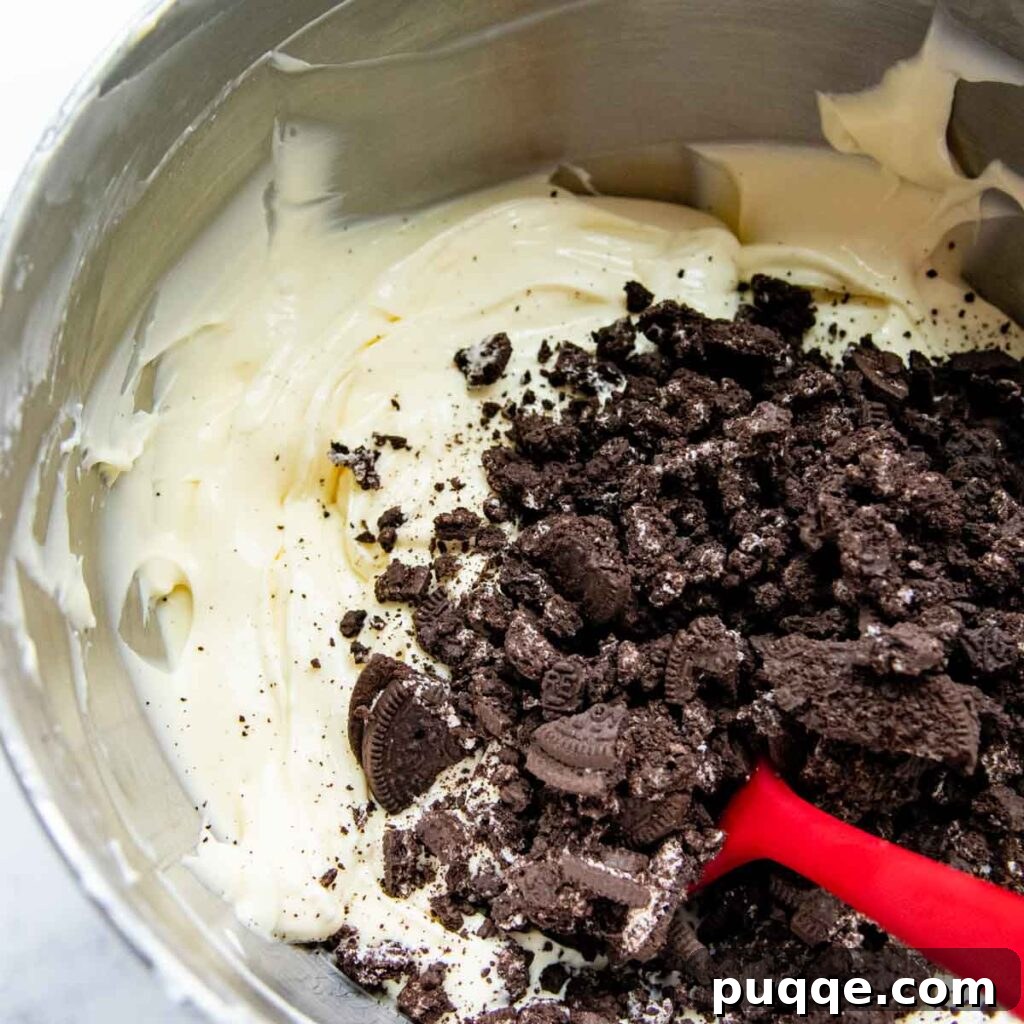 Velvet Smooth Gluten-Free Oreo Cheesecake Bliss 7 Gluten-free Oreo chunks being gently stirred into the creamy cheesecake batter.
