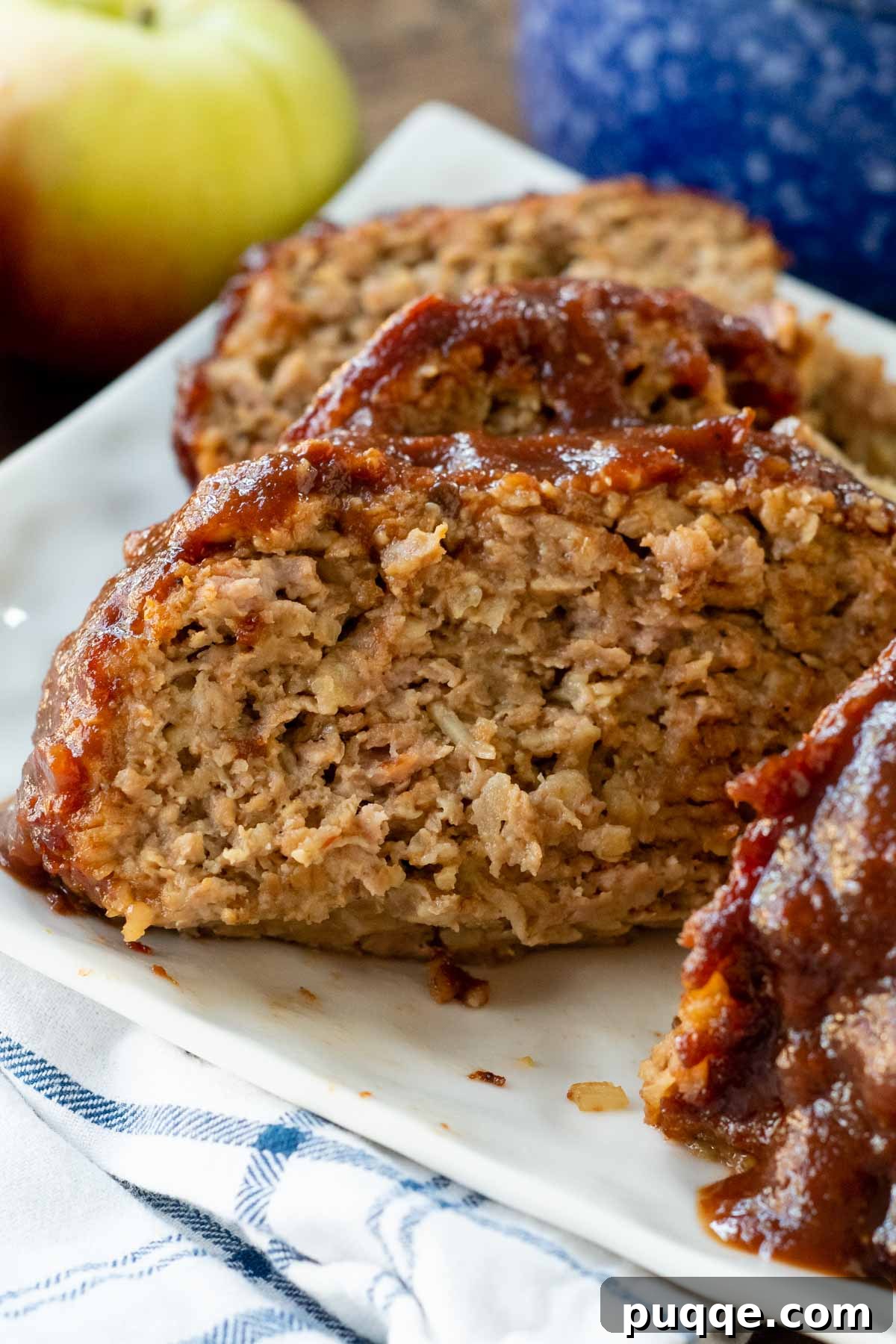Sliced pork meatloaf on a platter, showing its juicy texture and glaze.