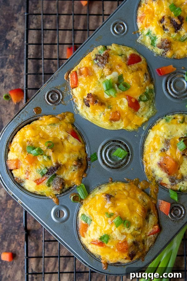 Delicious breakfast egg muffins in muffin tins, with chopped red peppers scattered around