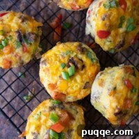 An overhead shot of a batch of freshly baked breakfast egg muffins arranged neatly on a wire cooling rack
