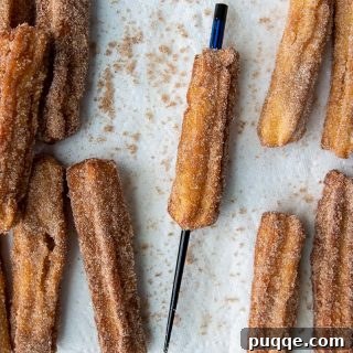 a chopstick going through cooked churros to make an opening for filling