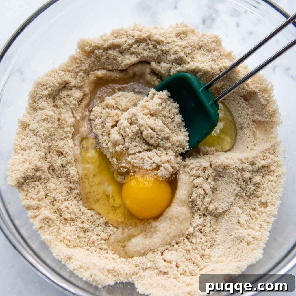 Eggs, oil, and vinegar being mixed into the dry ingredients.