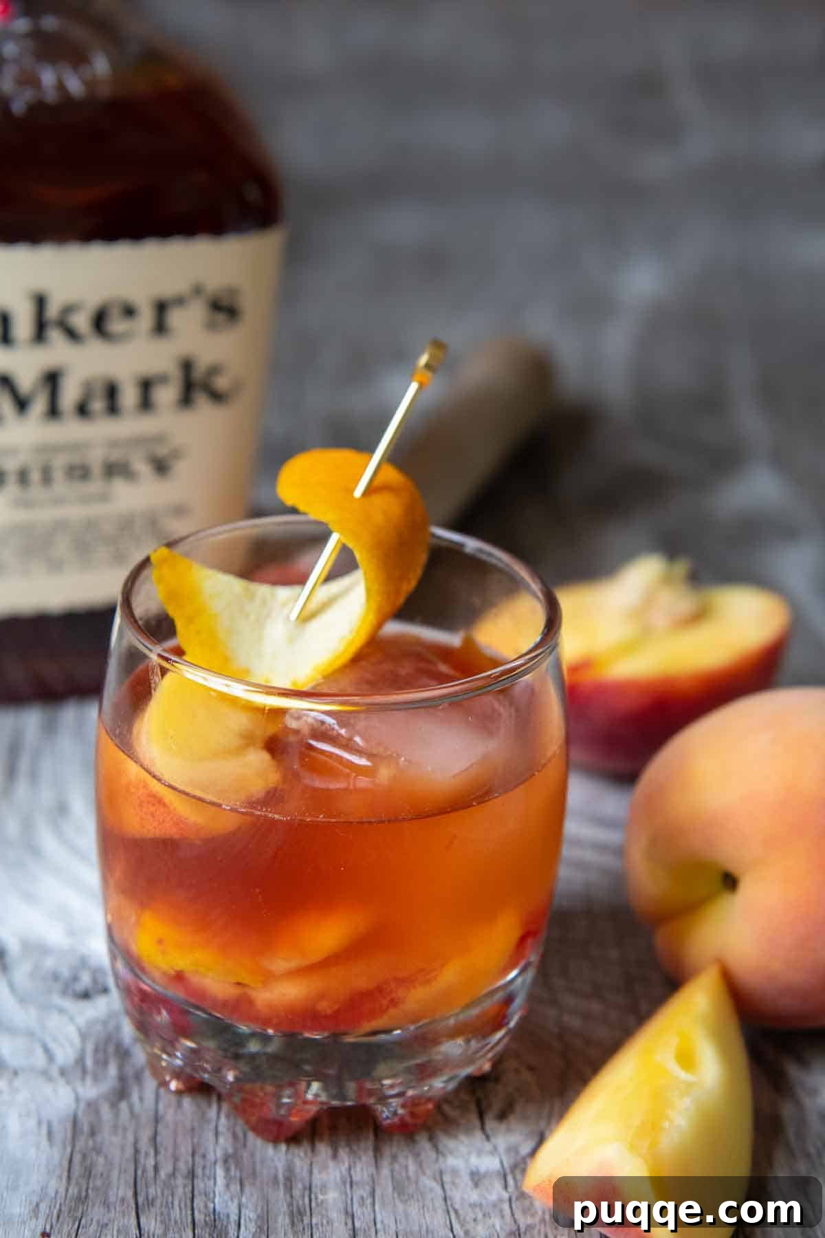The Ultimate Gluten-Free Alcohol Choices for 2024 4 A beautifully crafted peach old fashioned cocktail presented on a wooden board, with a bottle of bourbon softly blurred in the background, suggesting a gourmet gluten-free whiskey option.