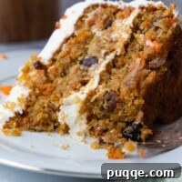 Cloud-Like Gluten-Free Almond Flour Carrot Cake 10 A close up of a bite taken out of a cake slice, showing the moist interior and frosting.