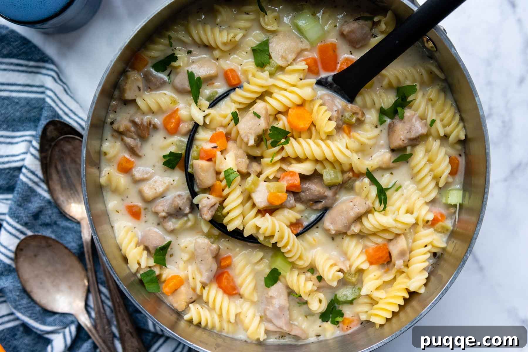 Effortlessly Flavorful Gluten-Free Chicken Noodle Soup 7 A large pot of rich gluten-free chicken noodle soup with a ladle, ready for serving.