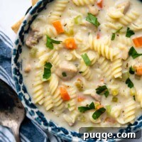 Effortlessly Flavorful Gluten-Free Chicken Noodle Soup 9 overhead shot of soup in a blue bowl.