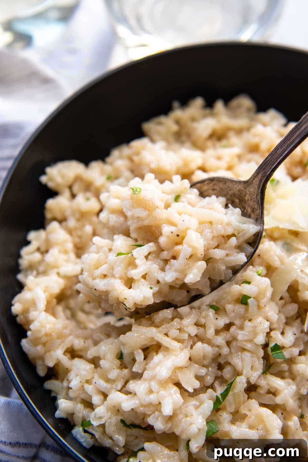 a spoon holding up a bite of risotto.