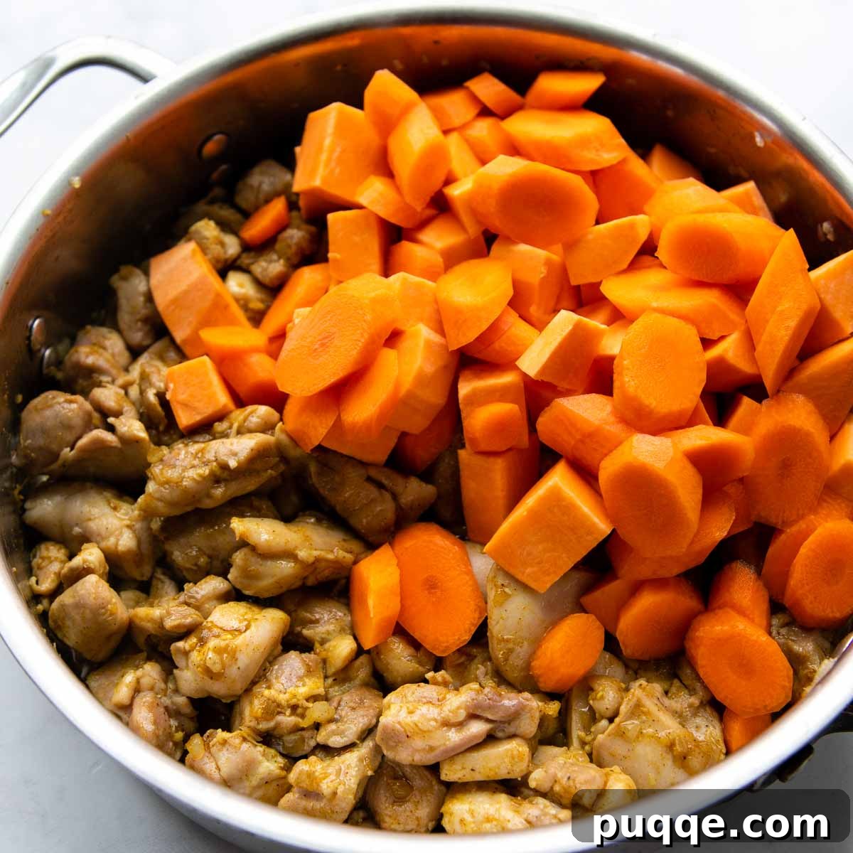 Your Go-To Gluten-Free Curry: Max Flavor, Minimal Effort 4 Carrots and sweet potatoes being stirred into the cooking chicken and aromatics.