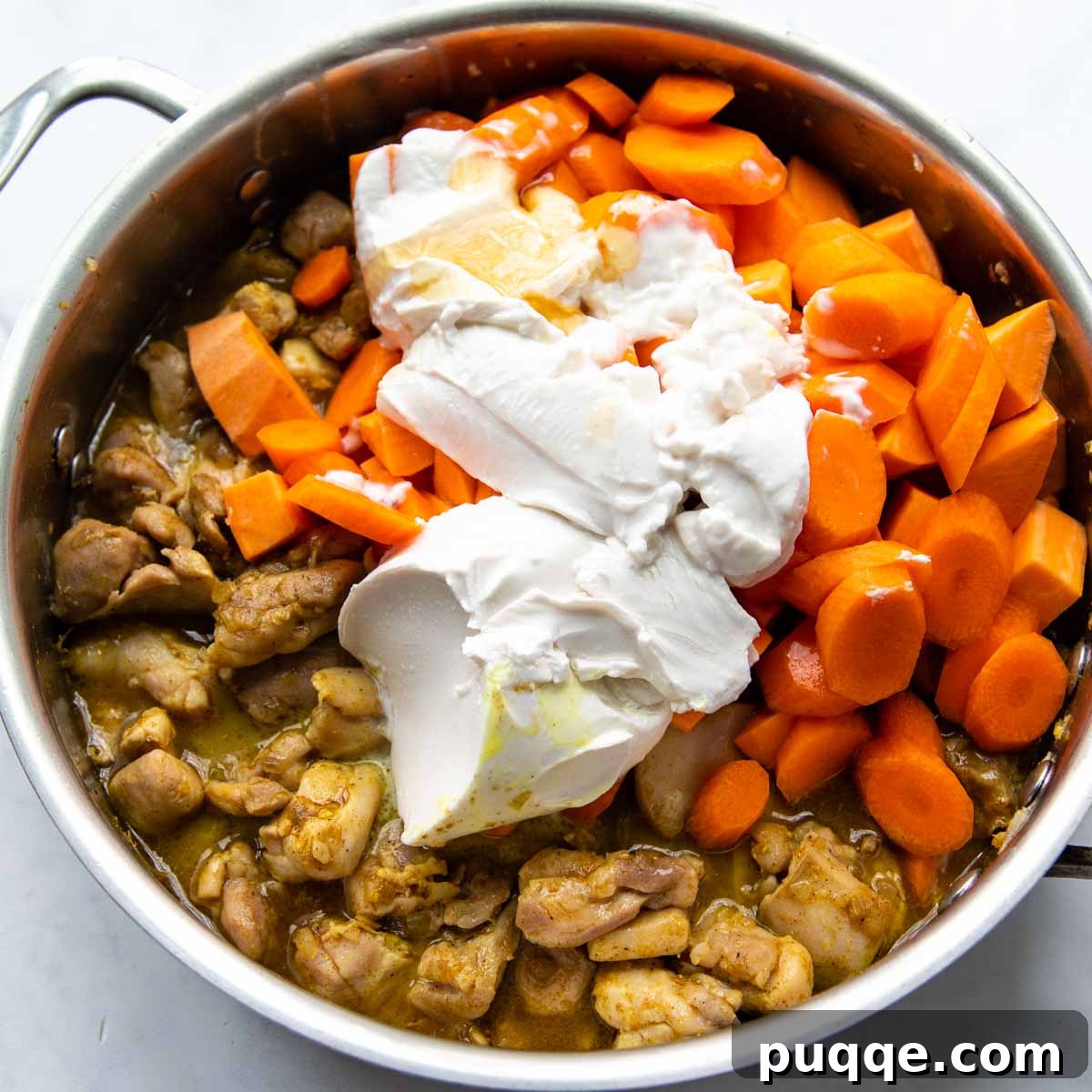 Your Go-To Gluten-Free Curry: Max Flavor, Minimal Effort 5 Creamy coconut milk being poured into the pan with the chicken and vegetables for the curry.