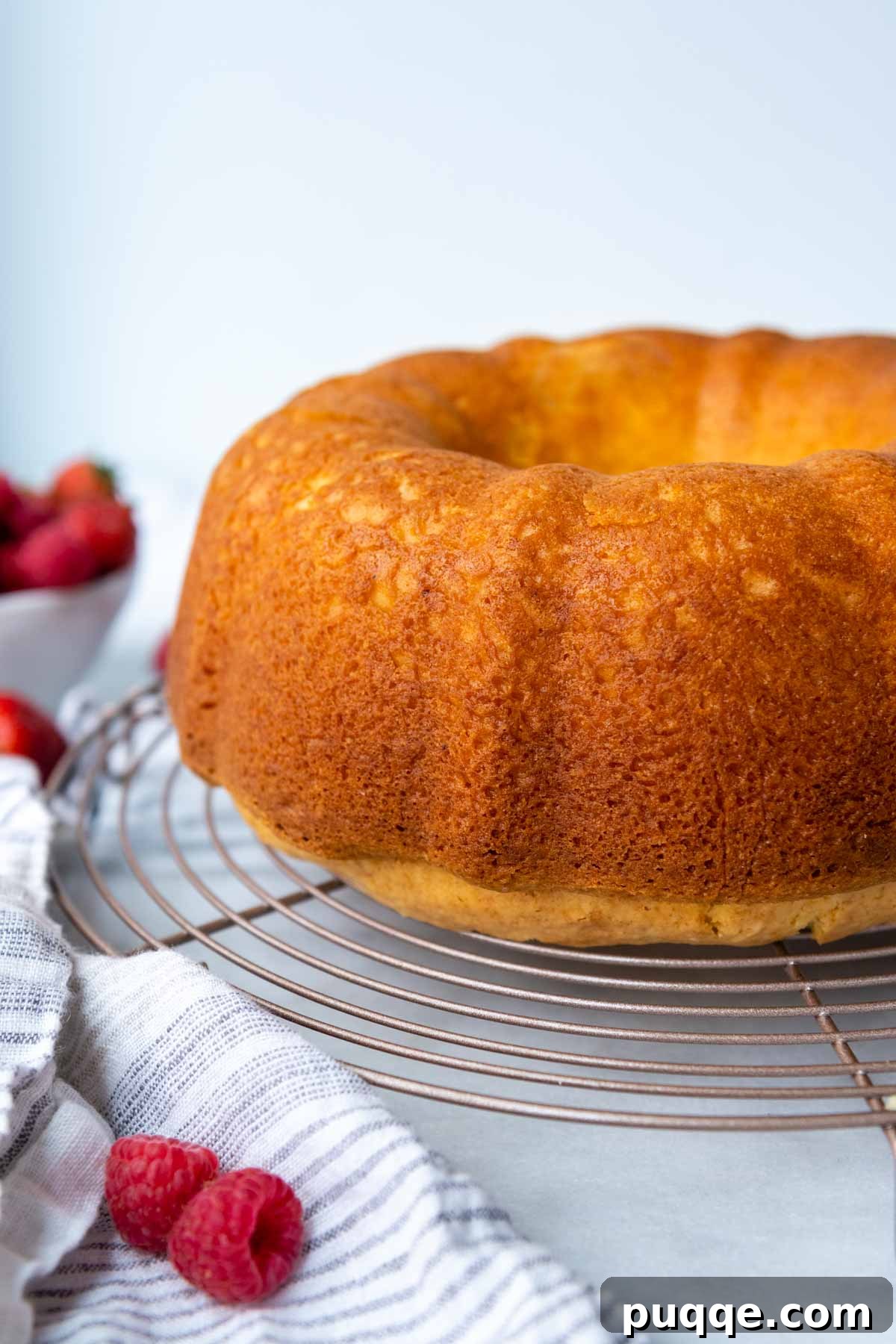 The Secret to Unbelievably Moist Gluten-Free Pound Cake 6 A freshly baked gluten-free bundt cake cooling on a wire rack, with a hint of marble counter in the background.