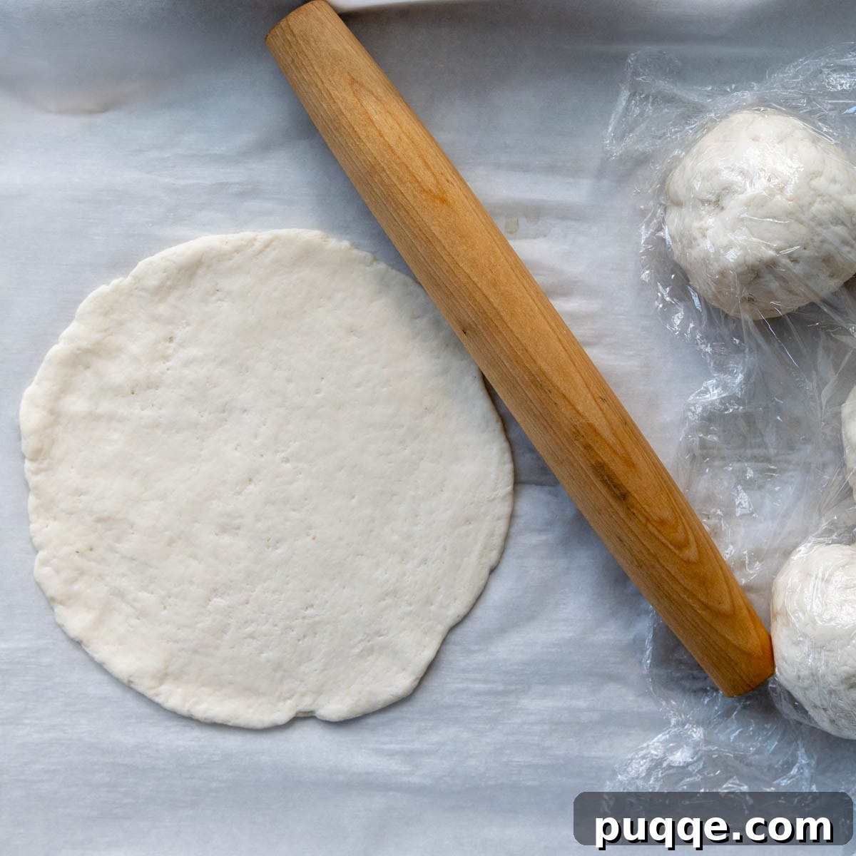 Foolproof Soft Gluten-Free Flatbread 7 A gluten-free flatbread rolled out into a perfect 6.5-inch circle on parchment paper, ready for cooking.