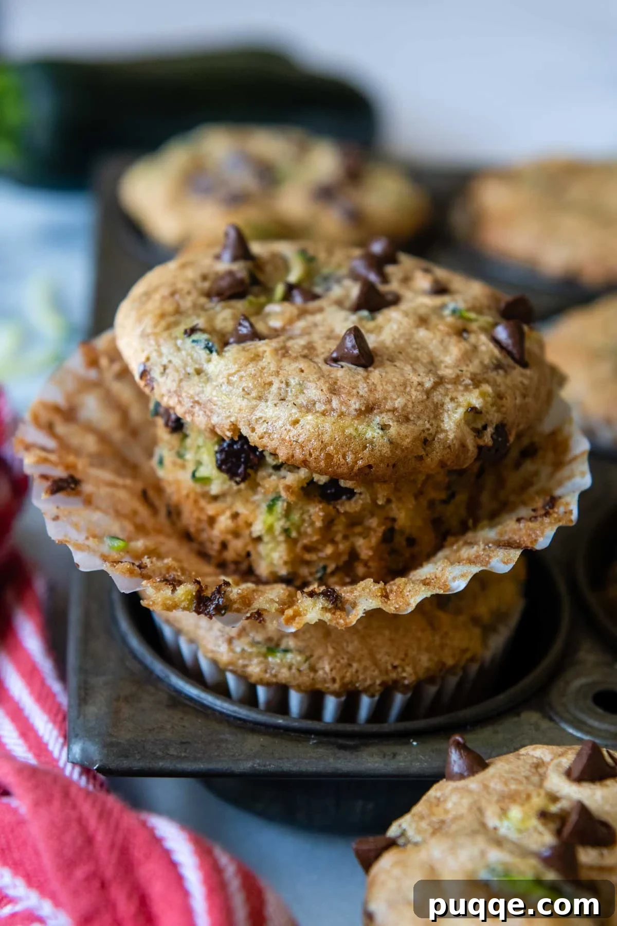A beautifully baked gluten-free zucchini muffin, unwrapped and sitting on a vintage muffin pan, ready to be enjoyed.
