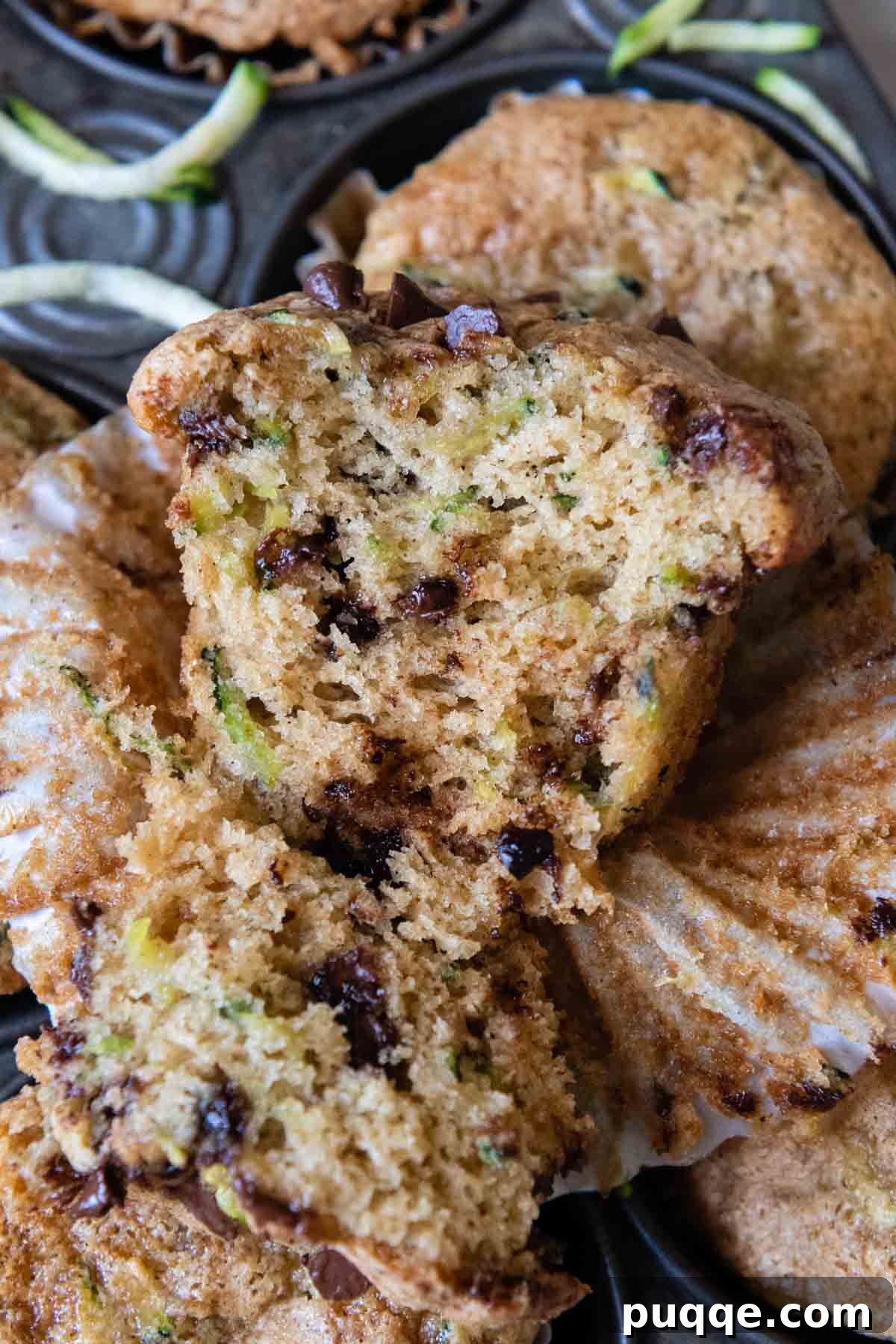 The inside of a perfectly baked gluten-free zucchini muffin, revealing delicious melted chocolate chips and an incredibly moist, tender crumb texture.