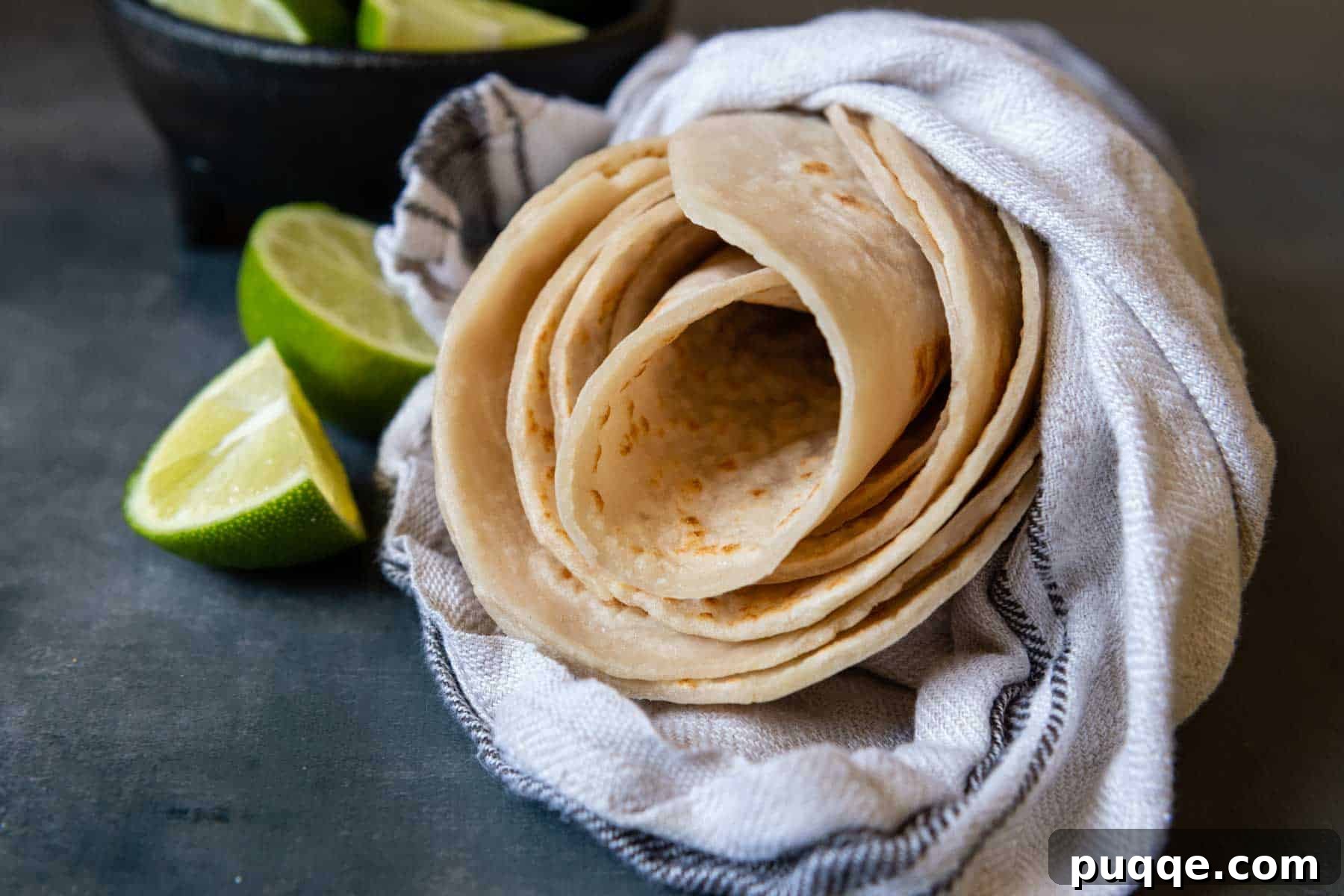 Freshly cooked gluten-free tortillas, neatly rolled and wrapped in a towel to stay warm.