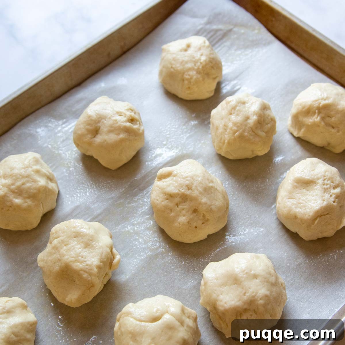 Individual gluten-free dough balls, perfectly portioned and ready for shaping, arranged on a baking sheet.