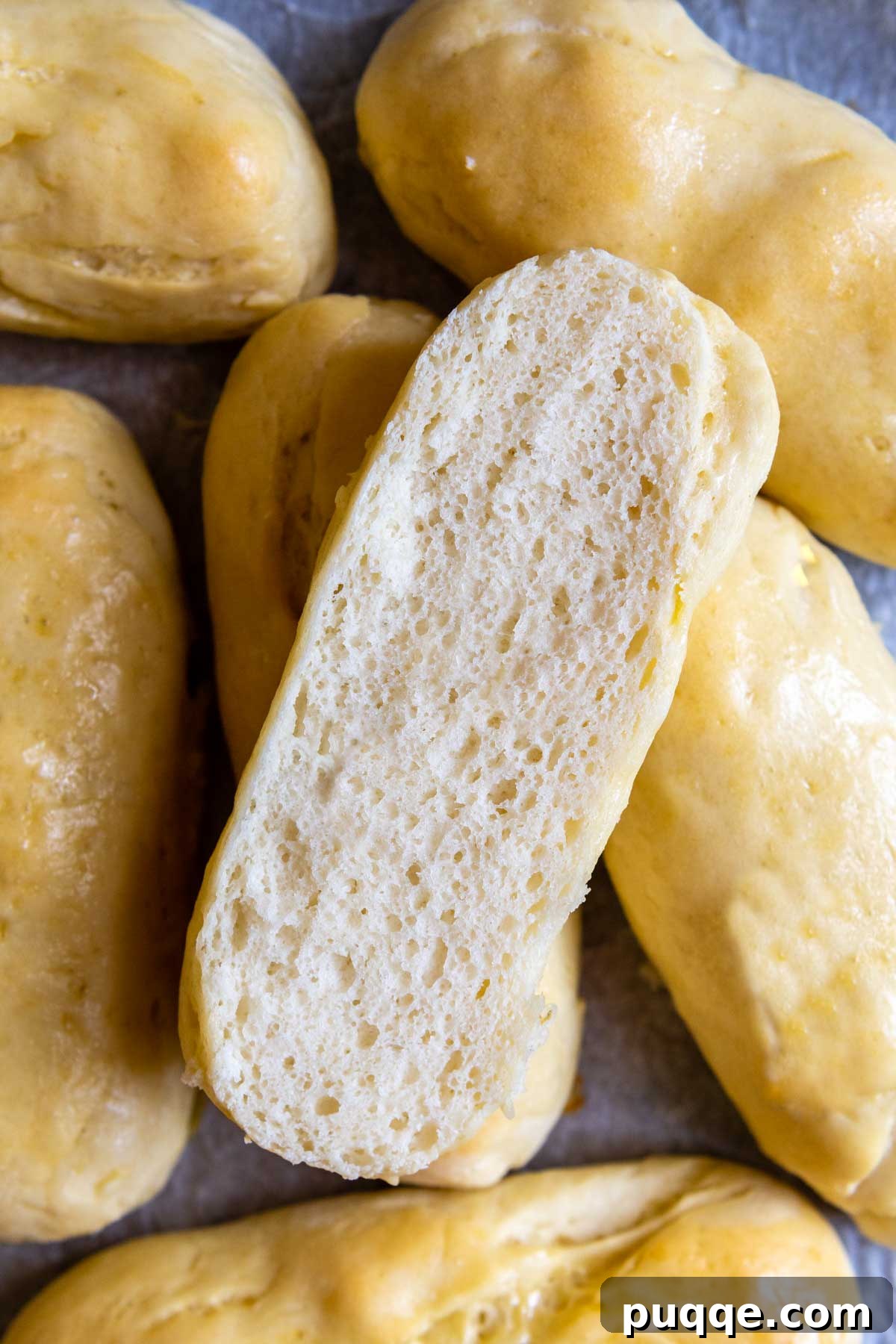 A perfectly baked gluten-free hot dog bun, sliced in half to reveal its soft, airy, and inviting interior texture.