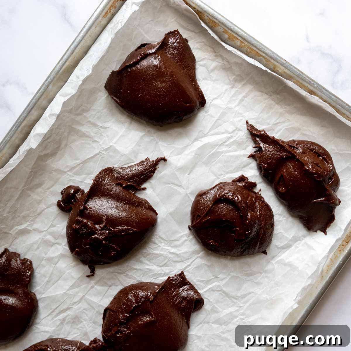 The Ultimate Gluten Free Ice Cream Sandwiches 5 Thick chocolate batter dolloped across a parchment-lined baking sheet.