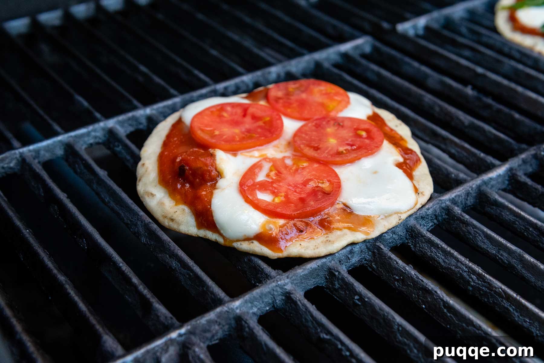 Grilling Gluten-Free Pizza: Easy Steps to Irresistible Results 7 a pizza cooking on a grill with tomatoes and mozzarella.