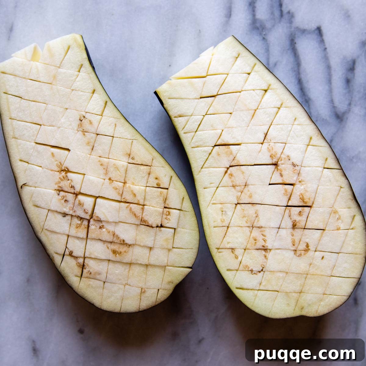 Hearty Gluten-Free Sausage-Filled Eggplant Boats 3 cut eggplant with crosshatch marks.