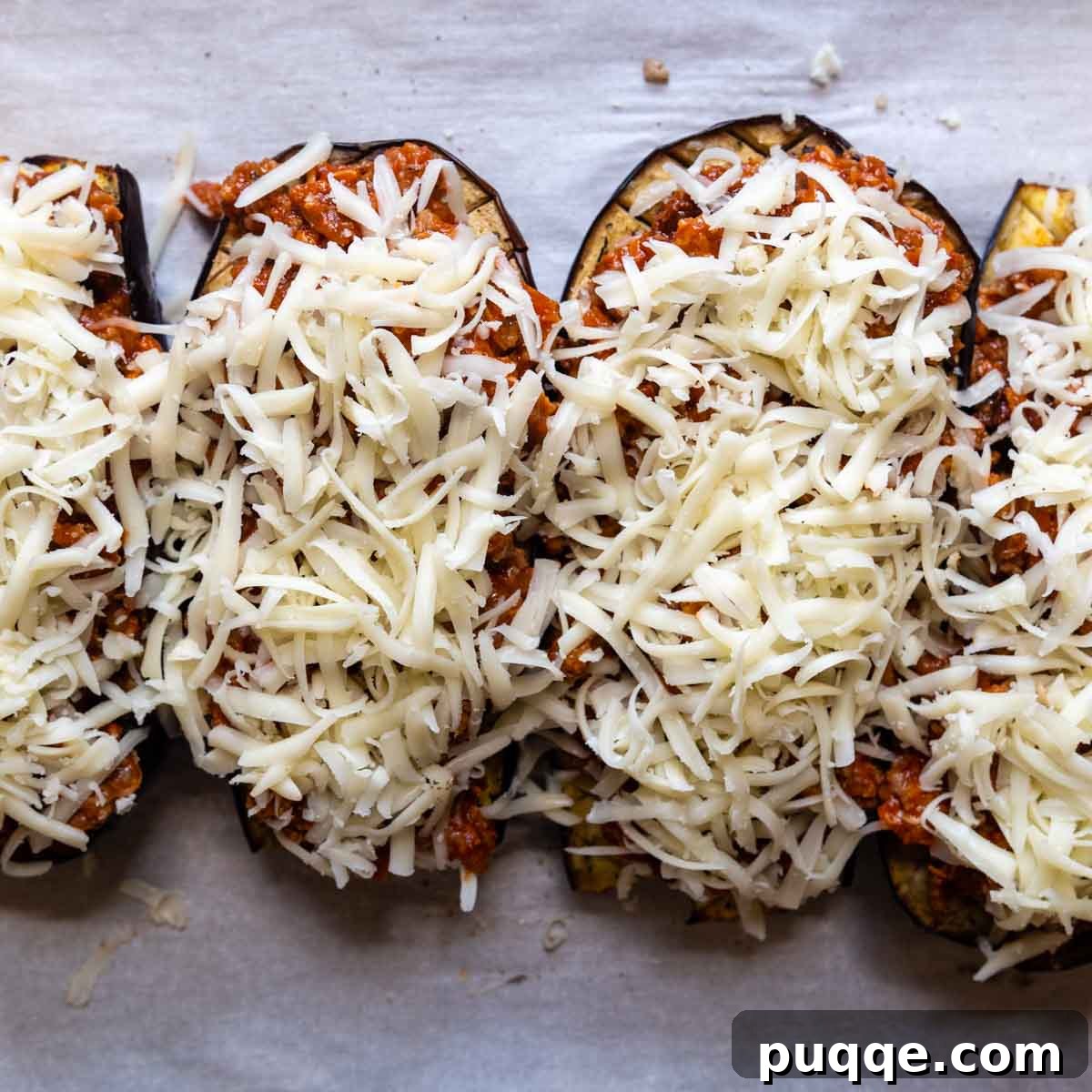 Hearty Gluten-Free Sausage-Filled Eggplant Boats 7 unbaked eggplant topped with cheese.