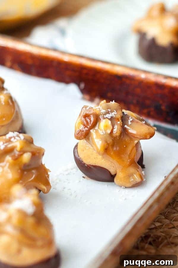 A close up of the candy on a baking sheet, showcasing their perfectly set chocolate and caramel toppings.