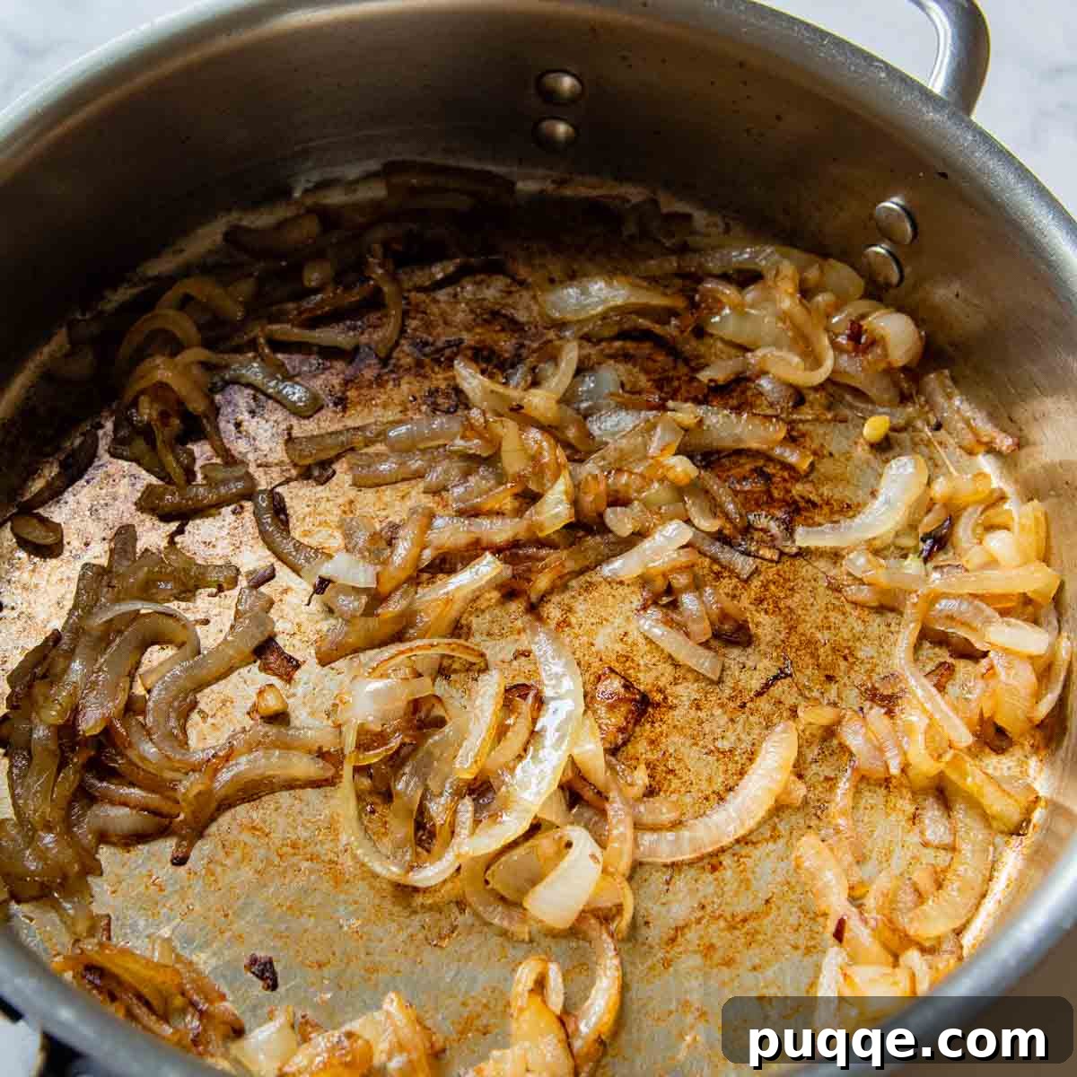 Gooey Cheeseburger Bowls with Crispy Bacon and Mystery Sauce 4 Thinly sliced onions caramelizing to a rich golden-brown in a hot skillet, ready to add sweet depth to the burger bowls.
