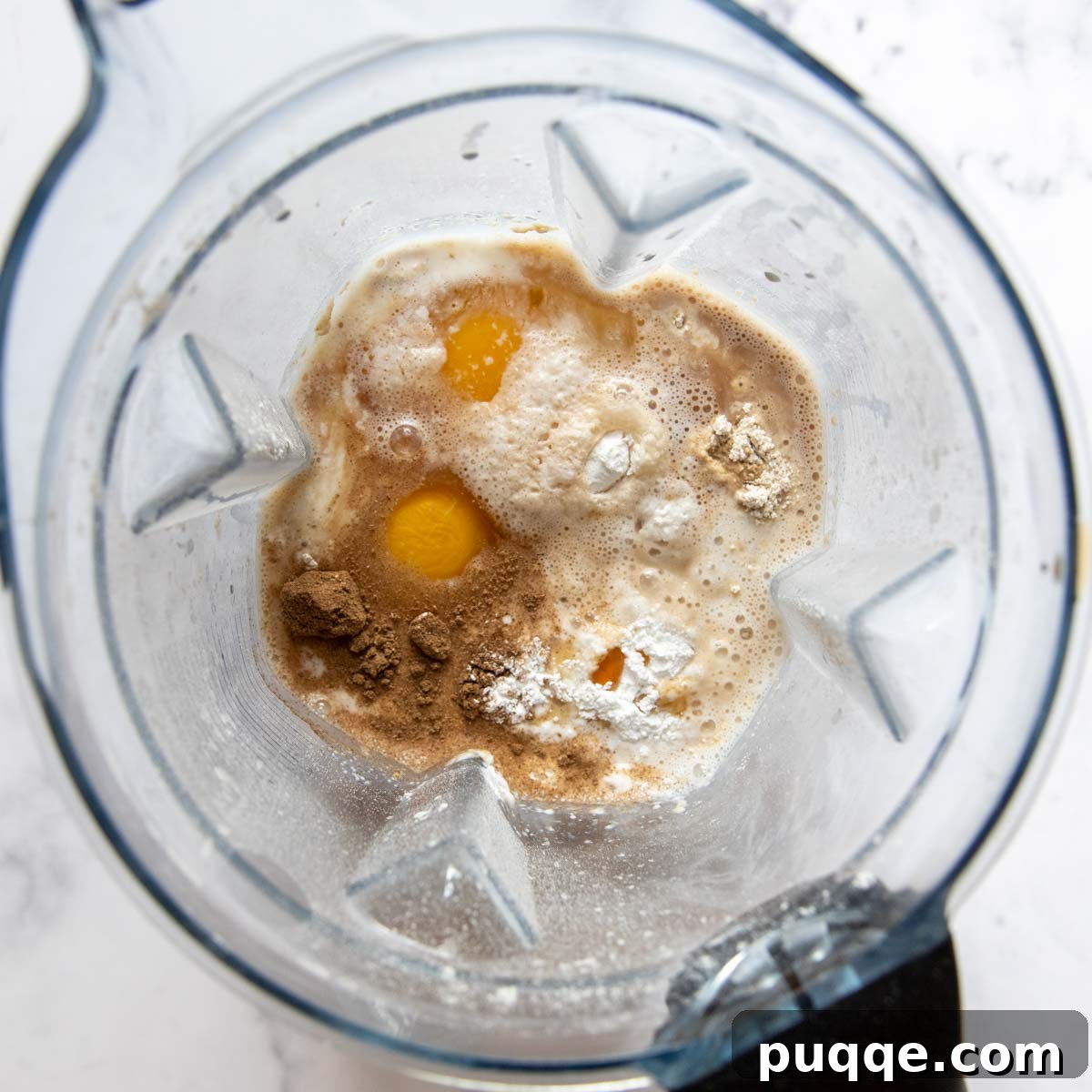 All wet and dry ingredients for oat flour pancakes combined in a blender cup, ready for mixing.