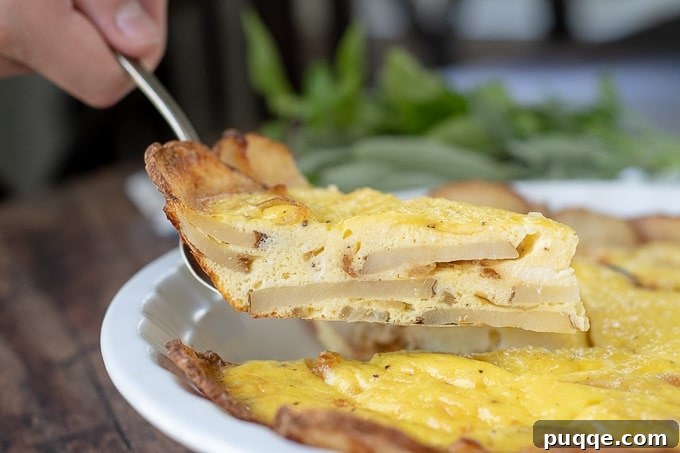 Golden Potato Frittata 6 A close-up shot of a spatula carefully lifting a perfect slice of potato frittata, highlighting the golden exterior and tender layers within.