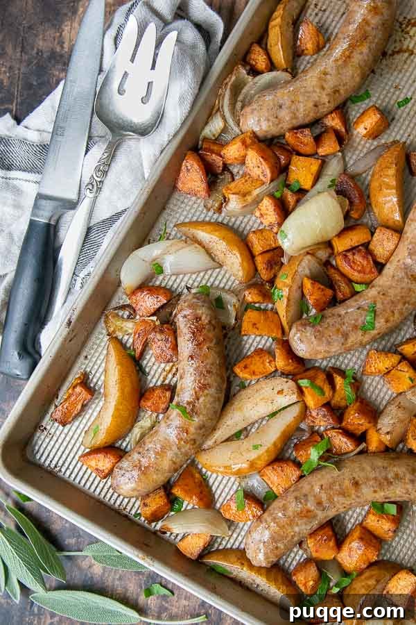 Sheet Pan Italian Sausage and Sweet Potato Bake 6 Overhead shot of a finished sheet pan sausage bake with roasted sweet potatoes, onions, and pears, golden and ready to serve.