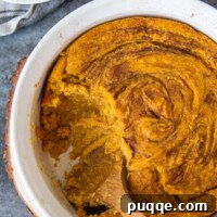 Overhead shot of sweet potato spoon bread casserole with a scoop taken out, showing the texture.