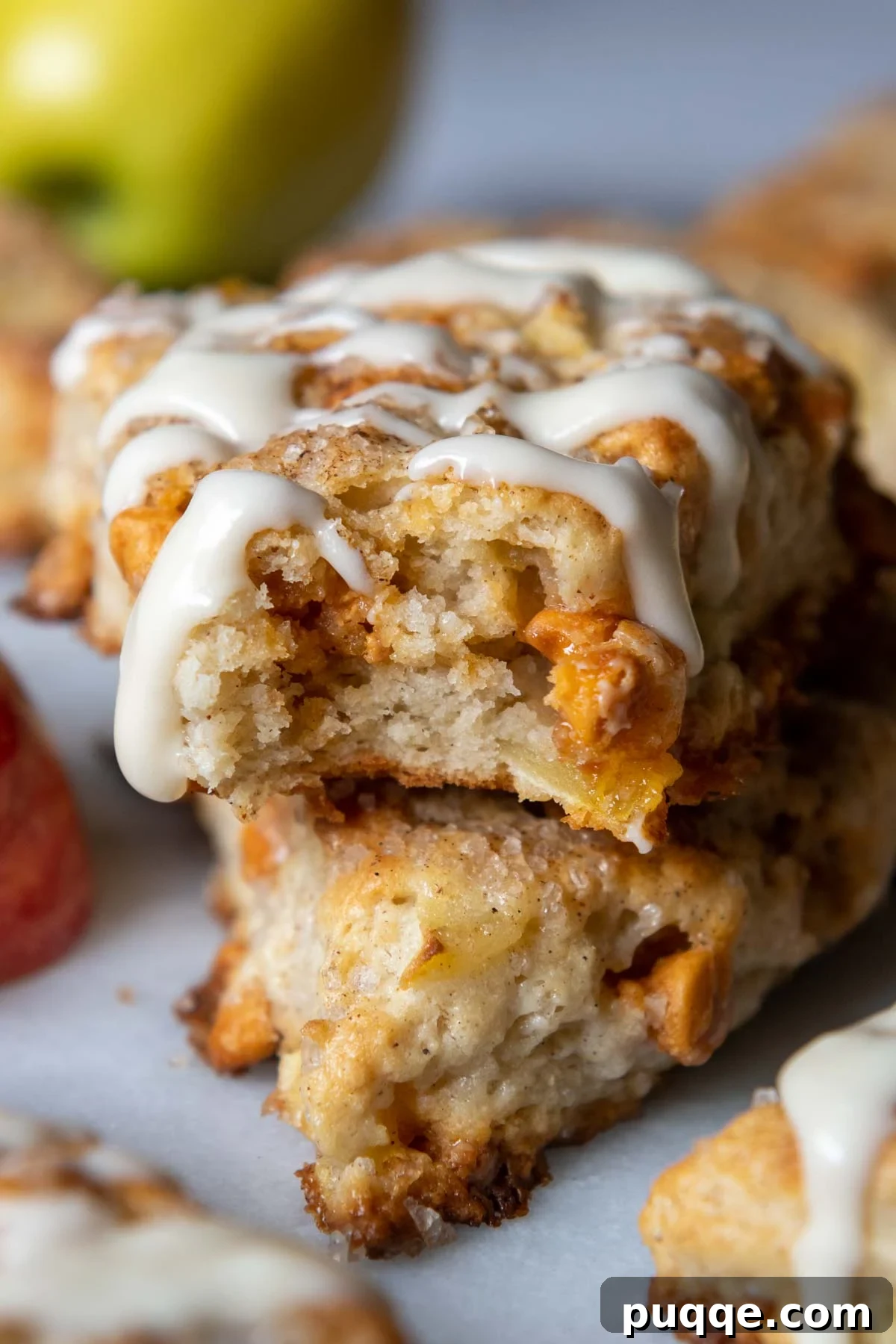 A perfectly baked gluten-free apple scone with a bite taken out, showcasing its fluffy interior and apple pieces.