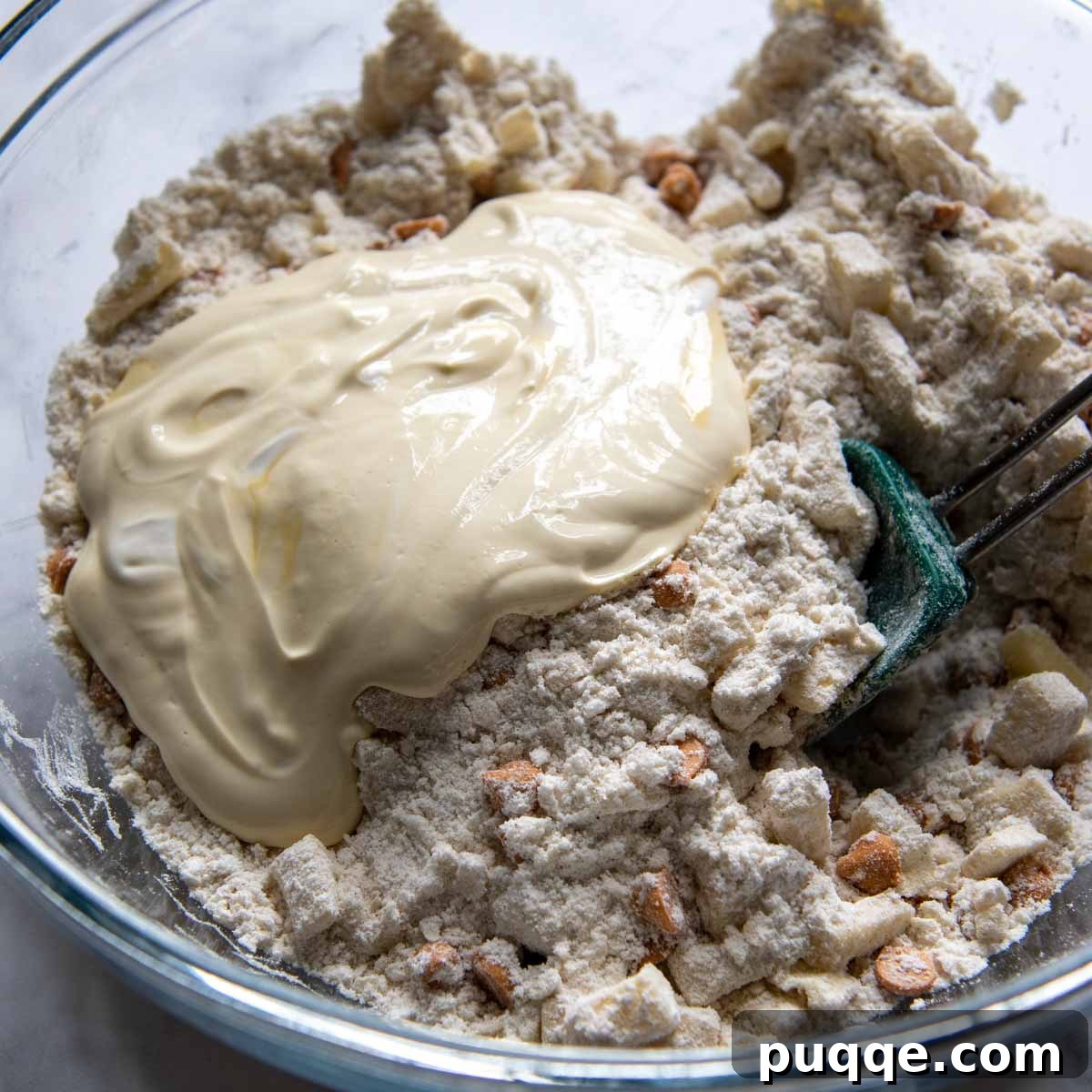 Liquid ingredients (sour cream, egg yolk, vanilla) being stirred into the flour mixture.