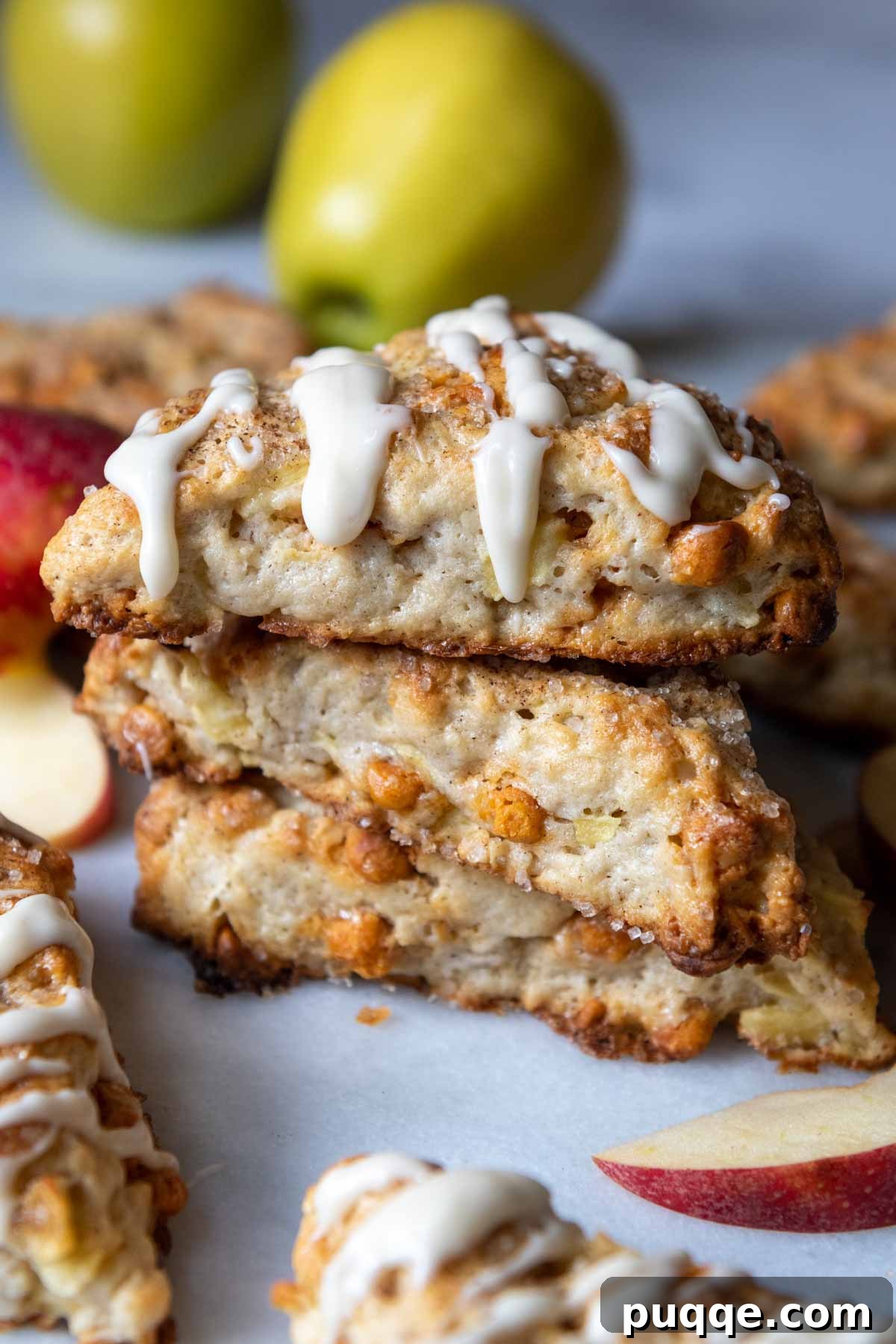 A stack of golden gluten-free apple scones, with a delicate glaze drizzled over the top one.