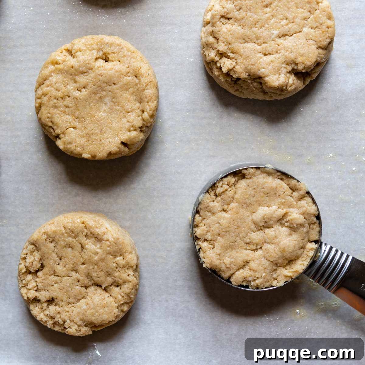 Cloud-Like Gluten-Free Oat Drop Biscuits 6 portioned oat flour biscuit dough dropped onto a parchment-lined baking sheet.