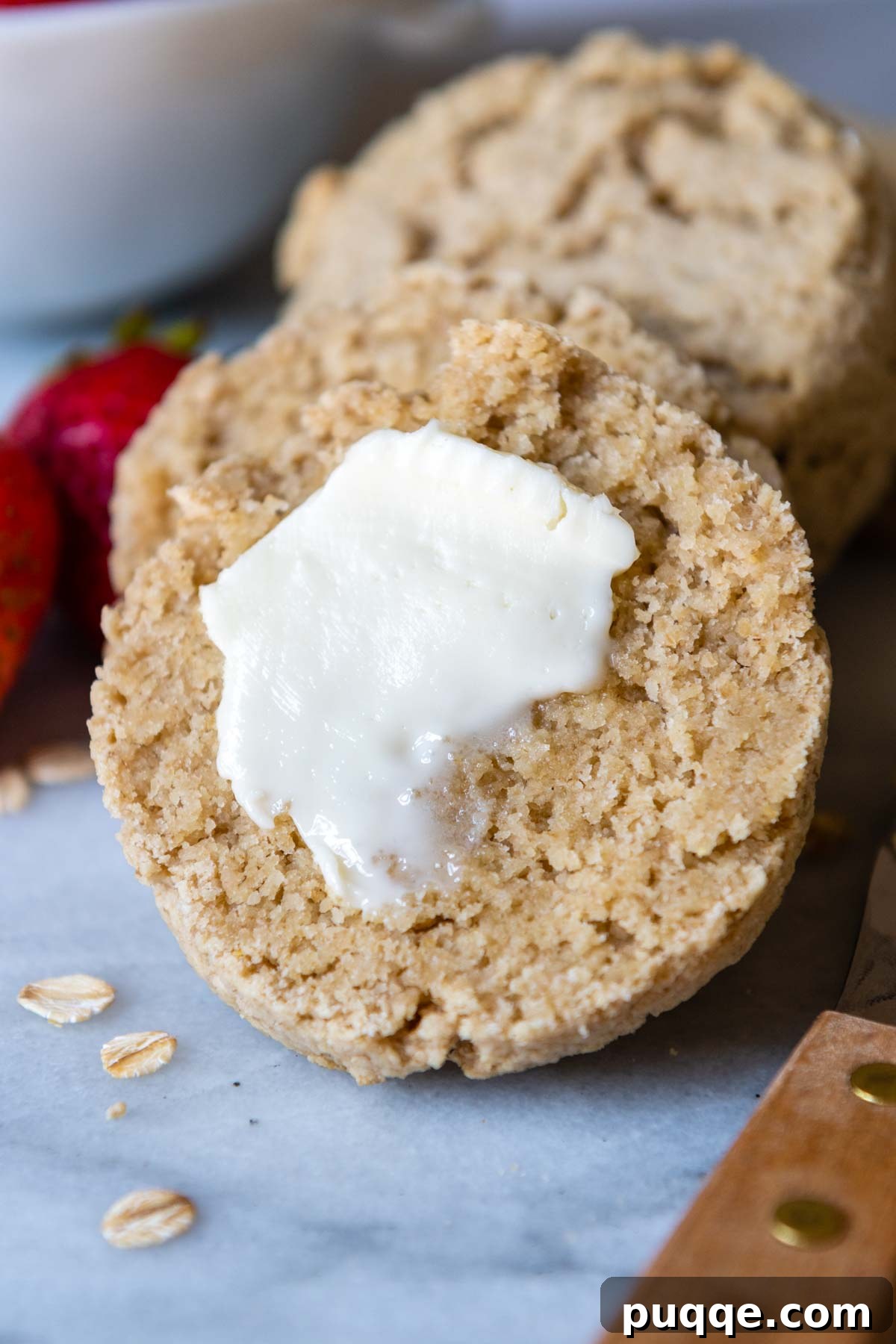 Cloud-Like Gluten-Free Oat Drop Biscuits 8 a freshly baked oat flour biscuit sliced in half, revealing a tender crumb, with melting butter on top.