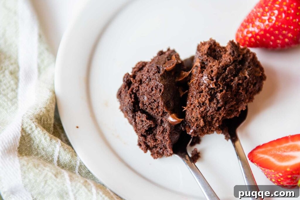 Effortless Gooey Fudgy Gluten-Free Mug Brownie 6 two spoons of brownies next to each other on a white plate.