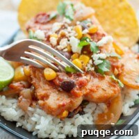 A fork about to cut into a plate of Mexican fish served on rice