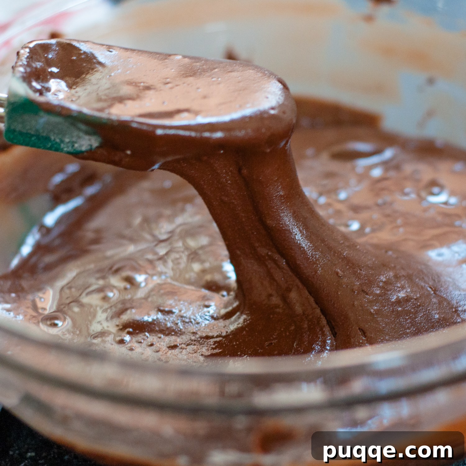 Intensely Fudgy Flourless Chocolate Chews 5 a spoon coming out of the batter bowl.
