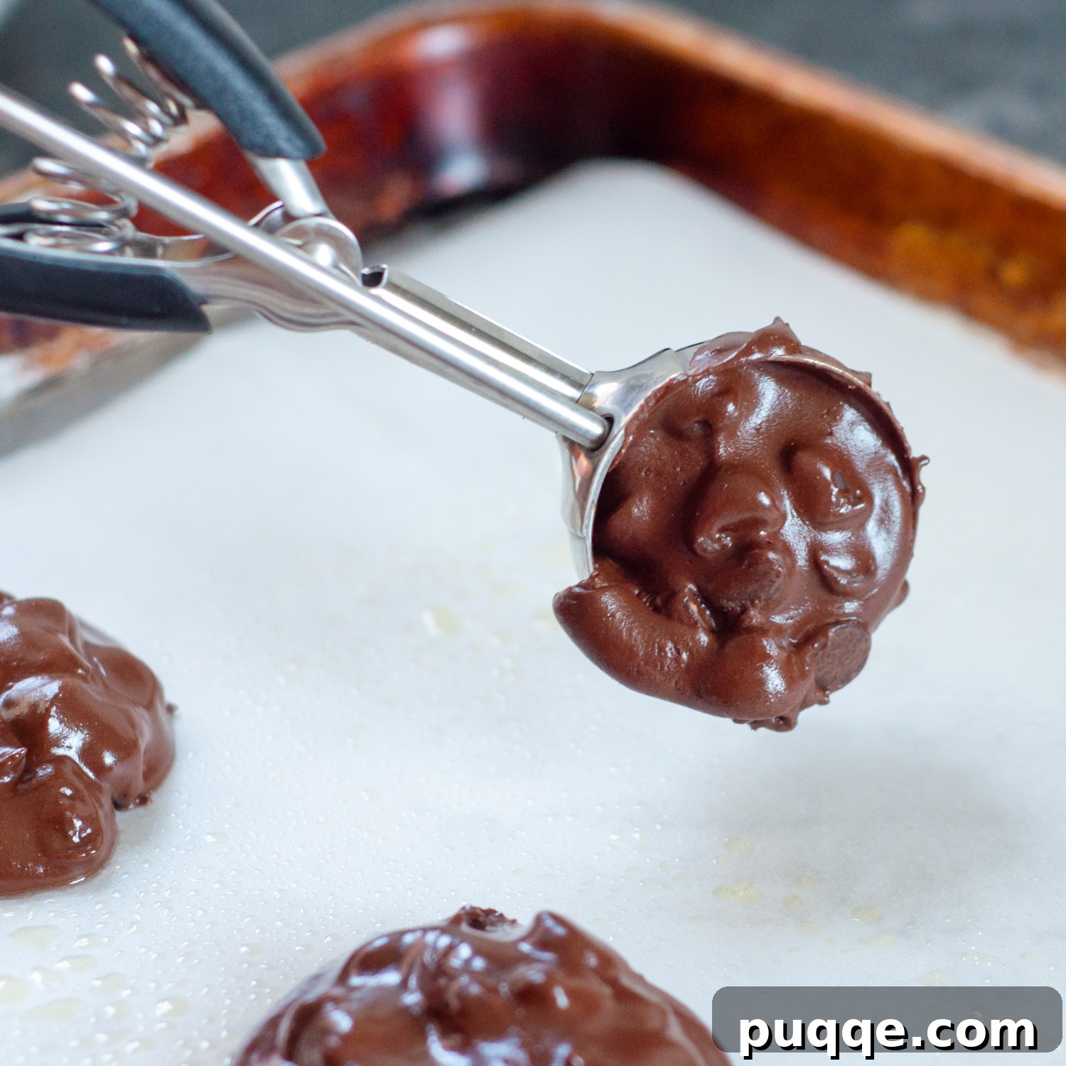 Intensely Fudgy Flourless Chocolate Chews 6 cookie scoop placing batter on a baking sheet.