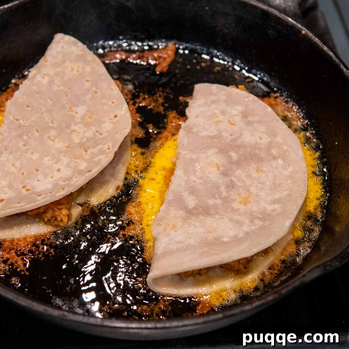10-Minute Gluten-Free Cheesy Crunchwrap Quesadillas 6 a frying pan cooking quesadillas with a cheesy crust.