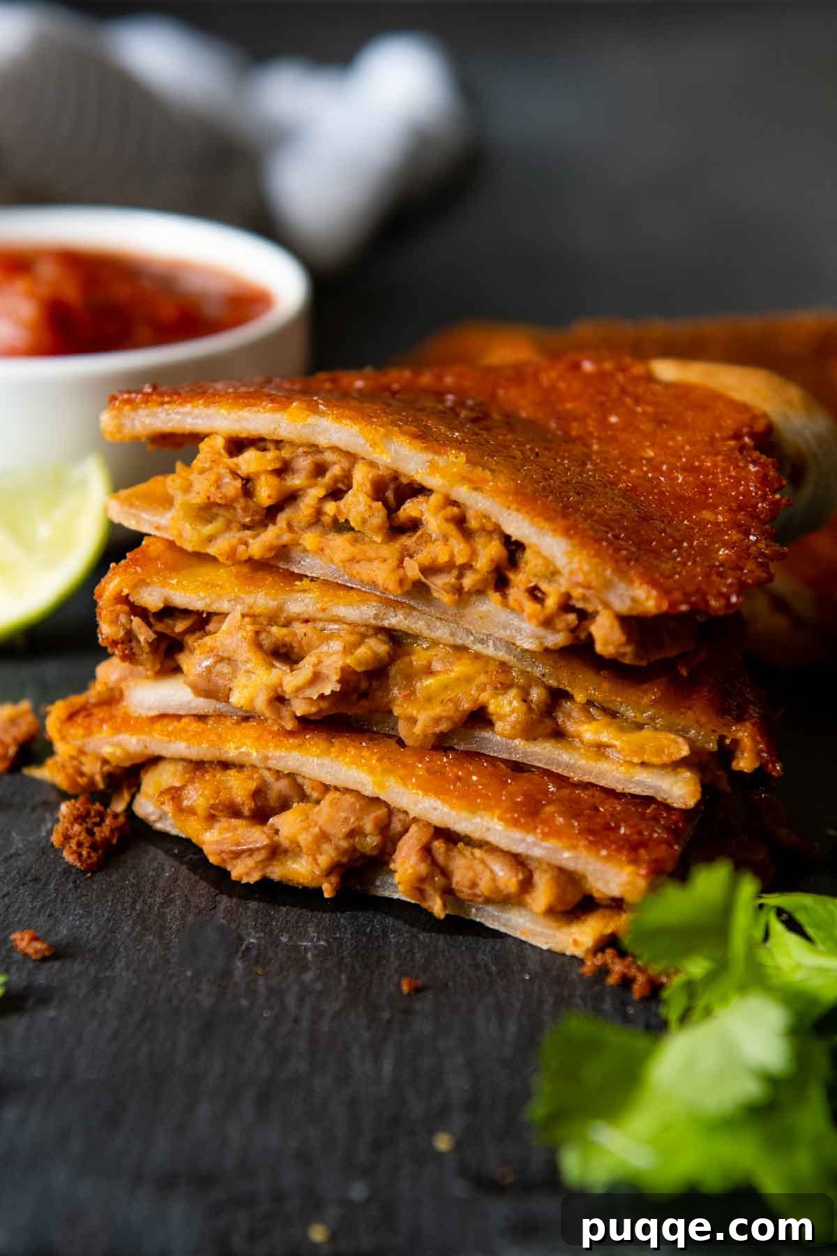 10-Minute Gluten-Free Cheesy Crunchwrap Quesadillas 7 a stack of 3 bean and cheese quesadillas with the filling peeking out.