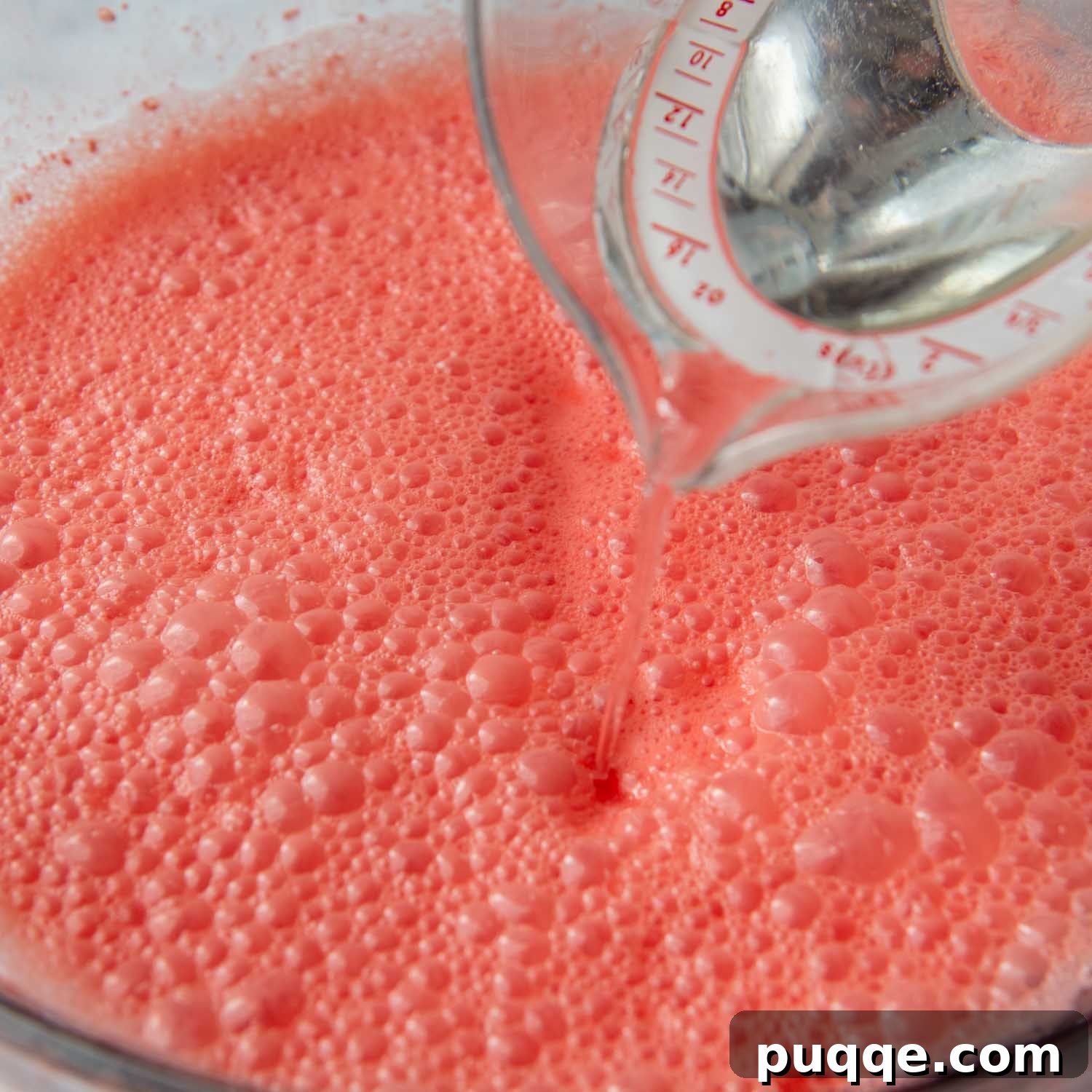 The blended Jello and cream cheese mixture, now with cold water, being poured into a serving dish.