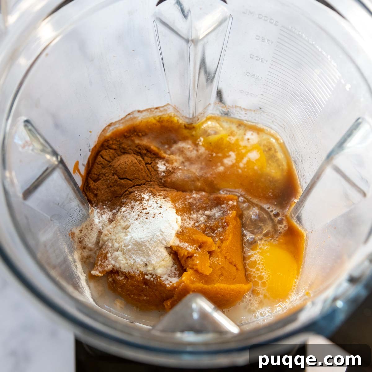 Raw ingredients for pumpkin pancakes in a blender, ready to be processed.