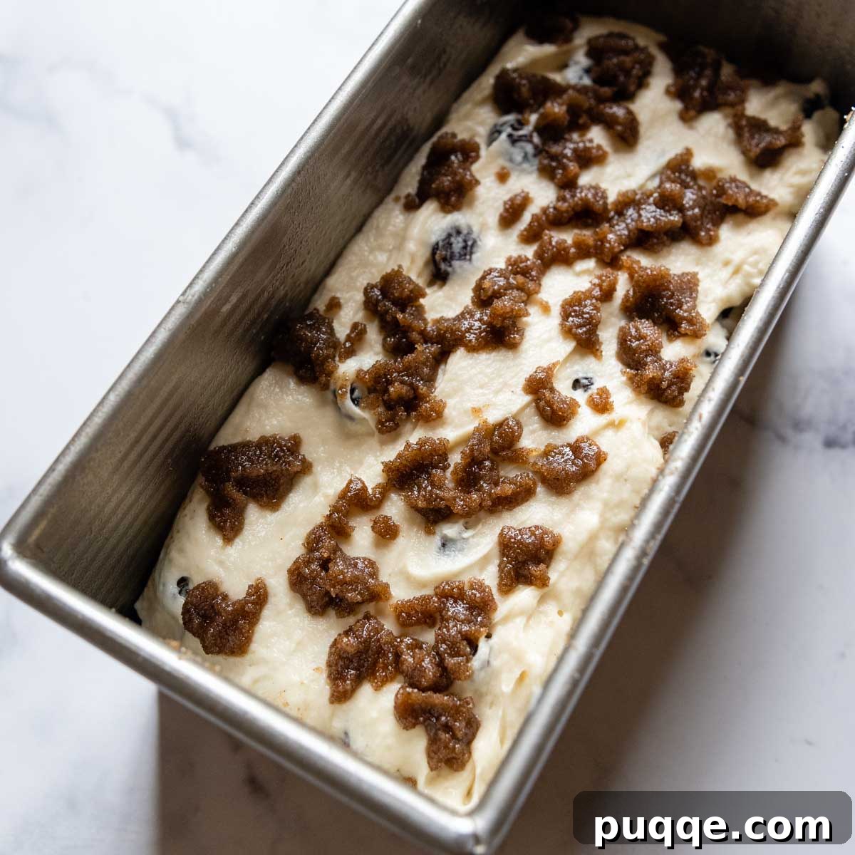 Cinnamon mixture dolloped on top of unbaked bread dough.